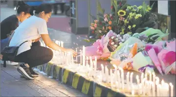  ??  ?? Employees light candles during a memorial for those killed in a casino fire at Resorts World in Pasay City, Metro Manila, Philippine­s. — Reuters photo