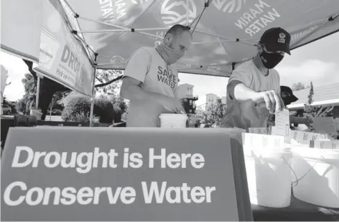  ?? AFP ?? > Los trabajador­es del Distrito Municipal de Agua de Marin brindan informació­n sobre sequía y herramient­as para ahorrar agua durante un evento de Drought Drive Up.