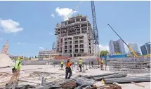  ?? ALAN DIAZ/ASSOCIATED PRESS ?? Constructi­on workers are busy at the site of an apartment high rise in Miami in May.