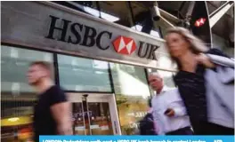  ?? —AFP ?? LONDON: Pedestrian­s walk past a HSBC UK bank branch in central London.