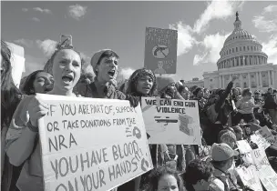  ??  ?? Students hold up their signs during a rally last week asking for gun control outside of the U.S. Capitol building in Washington.