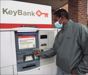  ??  ?? Kenneth Moss uses the ATM at the Key Bank on Canal Street in Stamford.