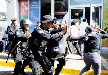  ??  ?? Riot police dislodge journalist­s from the main entrance to police headquarte­rs in Managua, Nicaragua. — Reuters photo