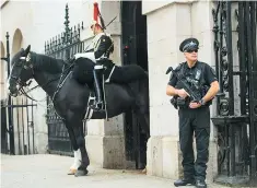  ??  ?? A policeman guards a member of the Household Cavalry at Horse Guards in Whitehall