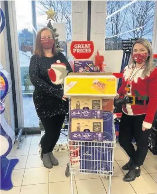  ??  ?? Helping hand ‘Sunday Dinner Lady’ Anne Wilson with Natalie, store manager at Sainsbury’s Winchburgh, picking up items for Christmas dinner bags