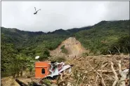  ?? ESTEBAN BIBA — POOL PHOTO VIA AP ?? A helicopter flies over the massive, rain-fueled landslide Nov. 7 in the village of Queja, in Guatemala.