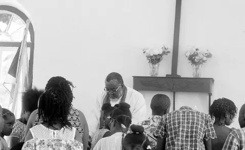  ?? PHOTO BY TAMARA BAILEY ?? Reverend Shaun Nisbeth praying for the children recently at the St Stephen’s Anglican Church in Chantilly.