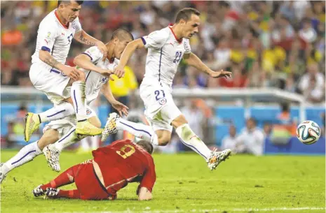  ?? BERNAT ARMANGUE, AP ?? Three Chile players run past Fernando Torres on Wednesday. Chile won 2-0, eliminatin­g defending World Cup champion Spain.