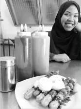  ??  ?? Hafsah Umar Barnett with a plate serving of churros. - Bernama photo