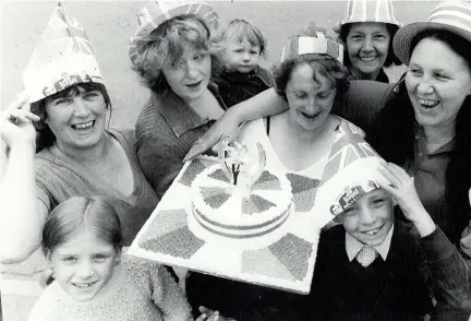  ??  ?? Carole Moore, organiser of the Wren’s Hill Road, Dudley, street party, displays the “wedding” cake to residents