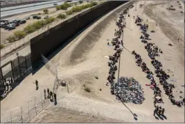  ?? ANDRES LEIGHTON — THE ASSOCIATED PRESS FILE ?? Migrants form lines outside the border fence waiting for transporta­tion to a U.S. Border Patrol facility in El Paso, Texas, on May 10.