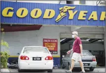  ??  ?? A man wearing a face mask walks in front of a Goodyear shop in Bukit Jalil, outskirts of Kuala Lumpur, Malaysia, Friday, June 11, 2021. (AP)