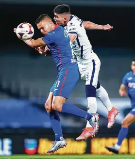  ?? Héctor Vivas / Getty Images ?? Jonathan Rodriguez (izq.) cabecea el balón frente a la marca de Johan Vásquez. El uruguayo anotó con un tiro penal y le dio el triunfo a Cruz Azul ante Pumas.