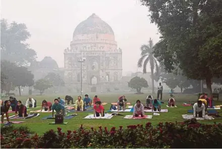  ?? FILE PIC ?? Yoga enthusiast­s practising at Lodhi Gardens in New Delhi amid heavy smog.