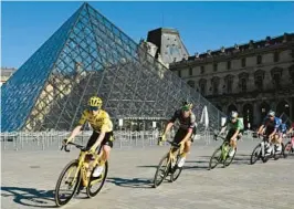  ?? BERTRAND GUAY/AP ?? Jonas Vingegaard, front, races past the Louvre Museum during the 21st stage of the Tour de France on Sunday.
