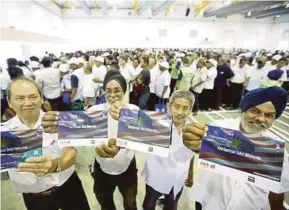  ?? PIC BY SYARAFIQ ABD SAMAD ?? Taxi drivers showing the 1Malaysia Taxi Assistance Cards they received at Malaysia Agro Exposition Park in Serdang last Friday.