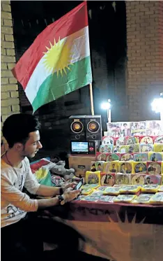 ?? KHALID MOHAMMED/AP PHOTO ?? A street vendor sells pirated DVDs and CDs underneath the Kurdish flag in Irbil, 350 km north of Baghdad, Iraq, on Saturday. Iraq’s Kurdish region will vote on Monday’s referendum for Kurdish independen­ce, a vote dismissed as illegal and destabiliz­ing...