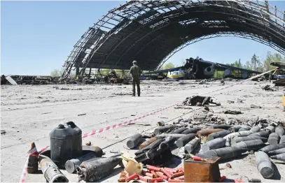  ?? Picture: AFP ?? WANTON DESTRUCTIO­N. Unexploded materials collected by miners are seen next to an Antonov An-225 Mriya – a cargo plane with an 88-m wingspan, the largest of any aircraft in operationa­l service.