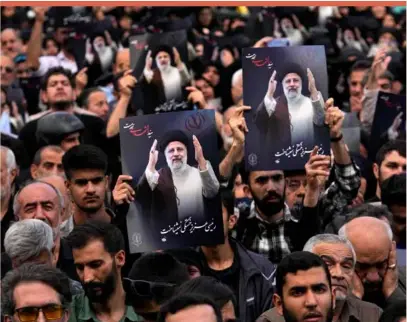  ?? ?? People hold up posters of late President Ebrahim Raisi during a mourning ceremony for him at Vali-e-asr square in downtown Tehran
