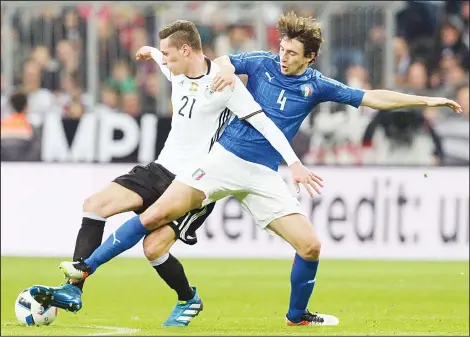  ??  ?? Germany’s Julian Draxler (left), and Italy’s Matteo Darmian challenge for the ball during a friendly soccer match between Germany and Italy at the Allianz Arena in
Munich, southern Germany, March 29.