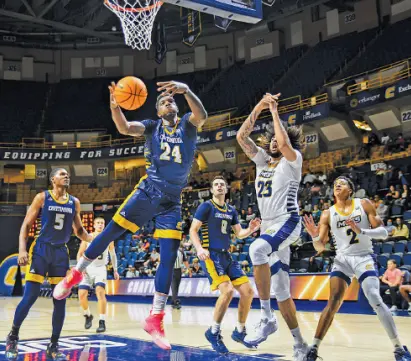  ?? PHOTO BY ANGELA FOSTER ?? The Blue team’s Silvio De Sousa (24) wins the rebound over the Gold team’s Avery Diggs (23) during the UTC men’s basketball team’s Blue & Gold intrasquad scrimmage Thursday night at McKenzie Arena.