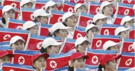  ??  ?? DAEGU: In this Aug 28, 2003 file photo, North Korean women hold national flags to cheer at the Daegu Universiad­e Games in Daegu, South Korea. Sports ties between the rival Koreas often mirror their rocky political ties. North Korea participat­ed in the...