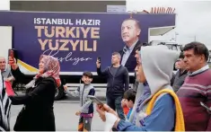  ?? — Reuters ?? People take pictures with their mobile phones at an election campaign point of Turkish President Tayyip Erdogan, ahead of the May 28 runoff vote, in Istanbul, Turkiye, on Sunday.
