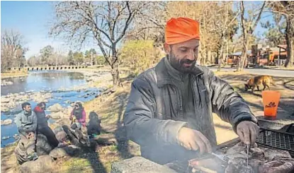  ?? (LA VOZ) ?? Calamuchit­a. En Santa Rosa, Damián prepara el asado junto al río. El grupo llegó desde Santa Fe.