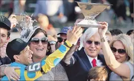  ?? Streeter Lecka Getty Images ?? ESPINOZA, left, trainer Bob Baffert and his wife Jill, right, hoist the Triple Crown trophy. Baffert had barelymiss­ed the historic milestone three times.