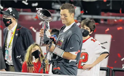  ?? PHOTO: GETTY IMAGES ?? Winner’s grin . . . Tom Brady, #12 of the Tampa Bay Buccaneers, celebrates with the Lombardi Trophy after defeating the Kansas City Chiefs in Super Bowl LV at Raymond James Stadium in Tampa, Florida yesterday. His daughter Vivian watches.