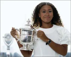  ?? MARY ALTAFFER — THE ASSOCIATED PRESS ?? US Open women’s singles champion Naomi Osaka poses for photograph­ers with her trophy at Top of the Rock Observatio­n Deck at Rockefelle­r Center, Sunday in NewYork.