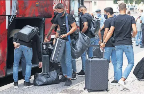  ??  ?? Los jugadores del Atlético sacan sus maletas del autobús al regreso de Lisboa.