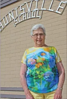  ??  ?? Former teacher Louise Reiter poses in front of the Huntsville School sign during a farewell tour of the old building, which is being replaced by a new school next door.