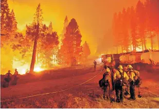 ?? NOAH BERGER/ASSOCIATED PRESS ?? The Caldor Fire burns along both sides of Highway 50 on Thursday as firefighte­rs work to stop its eastward spread in Eldorado National Forest, Calif.