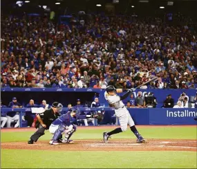  ?? Vaughn Ridley / Getty Images ?? Aaron Judge hits his 61st home run of the season in the seventh inning against the Blue Jays on Wednesday.