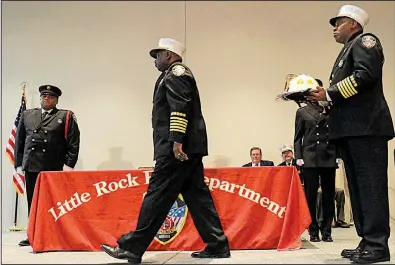  ?? Arkansas Democrat-Gazette/STATON BREIDENTHA­L ?? Former Little Rock Fire Chief Gregory Summers walks to the other side of the stage Wednesday after presenting new Fire Chief Delphone Hubbard with a helmet during a change-of-command ceremony.