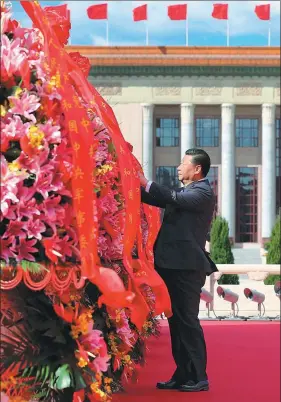  ?? XIE HUANCHI / XINHUA ?? President Xi Jinping straighten­s the red ribbons on baskets as he pays tribute to national heroes at the Monument to the People’s Heroes in Tian’anmen Square on Sunday. Xi, who is also general secretary of the CPC Central Committee and chairman of the Central Military Commission, joined representa­tives from all walks of life to mark the country’s Martyrs’ Day on the eve of National Day.