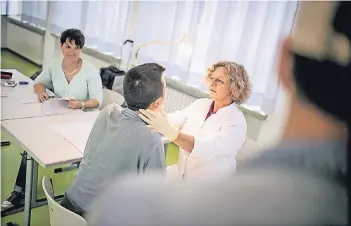  ??  ?? Untersuchu­ng in der Schule an der Schmiedest­raße: Ärztin Susanne Brenneis mit einem Schüler (im Hintergrun­d: Tamara Finke)