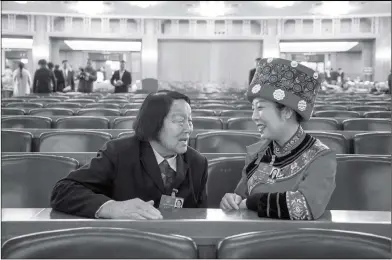  ??  ?? Shen Jilan (left), 89, a National People’s Congress (NPC) deputy from Shanxi Province, talks to NPC deputy Ran Hui from Chongqing Municipali­ty on Sunday. Shen is China’s longest serving deputy and has attended all 13 NPCs.