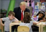  ?? AP PHOTO/EVAN VUCCI ?? President Donald Trump visits with a group of children during a tour of the Nationwide Children's Hospital on Friday in Columbus, Ohio.