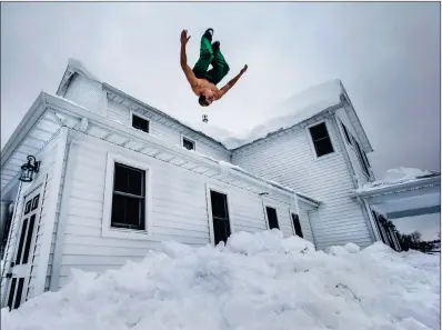  ?? PICTURE: REUTERS ?? FLIP IT: Phil Mohun does a back flip off his family home after clearing snow from the roof following a massive snowstorm in Cowlesvill­e, New York. Warm temperatur­es and rain were forecast, bringing the threat of widespread flooding.