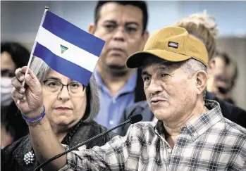  ?? JOSE A. IGLESIAS jiglesias@elnuevoher­ald.com ?? Former political prisoner Victor Manuel Sosa Herrera raises the Nicaraguan flag with the inverted national seal in the center as a sign of protest at the Stephen P. Clark Government Center in downtown Miami on Wednesday.