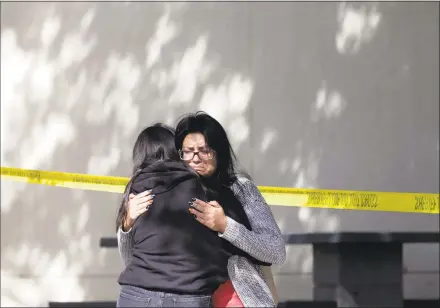  ?? Marcio Jose Sanchez / Associated Press ?? Mourners embrace outside of the Thousand Oaks Teen Center on Thursday, where relatives and friends gathered in the aftermath of the Wednesday night mass shooting in Thousand Oaks, Calif.