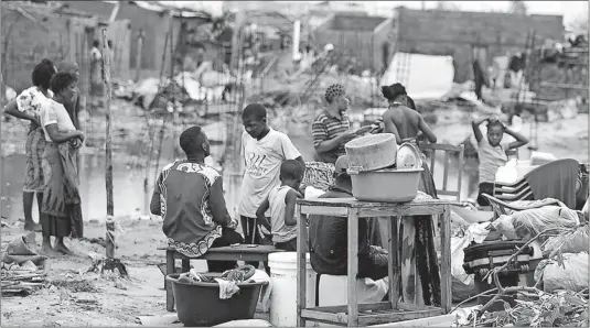  ?? [DENIS ONYODI/IFRC PHOTOS] ?? Residents of Beira, Mozambique, try to salvage what’s left of their belongings after Cyclone Idai hit the country on the southeaste­rn coast of Africa. President Filipe Nyusi says that more than 1,000 people could be dead from the storm.