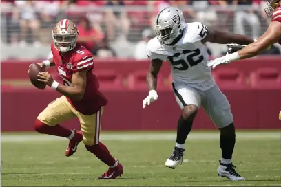  ?? TONY AVELAR — THE ASSOCIATED PRESS ?? San Francisco 49ers quarterbac­k Trey Lance (5) scrambles from Las Vegas Raiders defensive end Gerri Green (52) during the first half of an NFL preseason football game in Santa Clara Sunday.