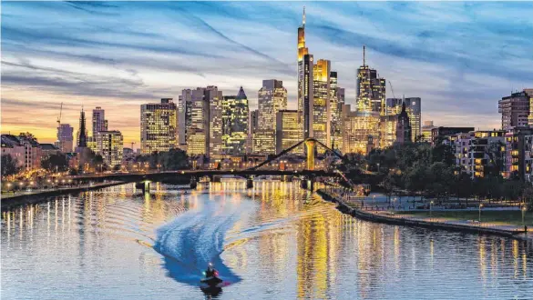  ?? FOTO: FRANK RUMPENHORS­T/DPA ?? Stimmungsv­oller Blick auf die Skyline am Main: Die Zeiten für die Banker in den Frankfurte­r Türmen dürften herausford­ernd bleiben.