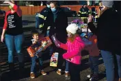  ??  ?? Families of Vacaville firefighte­rs help choose toys for needy children during the annual Vacaville Firefighte­rs Associatio­n Toy Drive.