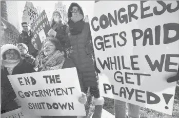  ?? MICHAEL DWYER/AP ?? Government workers and their supporters hold signs during a protest Friday in Boston. The workers rallied with Democratic U.S. Sen. Ed Markey and other supporters to urge the Republican president put an end to the shutdown so they can get back to work.