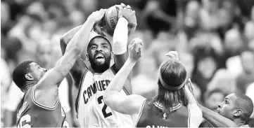  ??  ?? Cleveland Cavaliers’ Kyrie Irving drives to the basket between Boston Celtics’ Marcus Smart (left) and Kelly Olynyk during the second half in game four of the Eastern conference finals of the NBA Playoffs at Quicken Loans Arena. — USA TODAY Sports photo