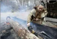  ?? STEVEN SENNE - THE ASSOCIATED PRESS ?? In this Nov. 15 photo, Mashpee Wampanoag Phillip Wynne, of Sagamore, Mass., pours water to control fire and temperatur­es while making a mishoon, a type of boat, from a tree at the Wampanoag Homesite at Plimoth Plantation, in Plymouth, Mass. Plymouth, where the Pilgrims came ashore in 1620, is gearing up for a 400th birthday, and everyone’s invited, especially the native people whose ancestors wound up losing their land and their lives.